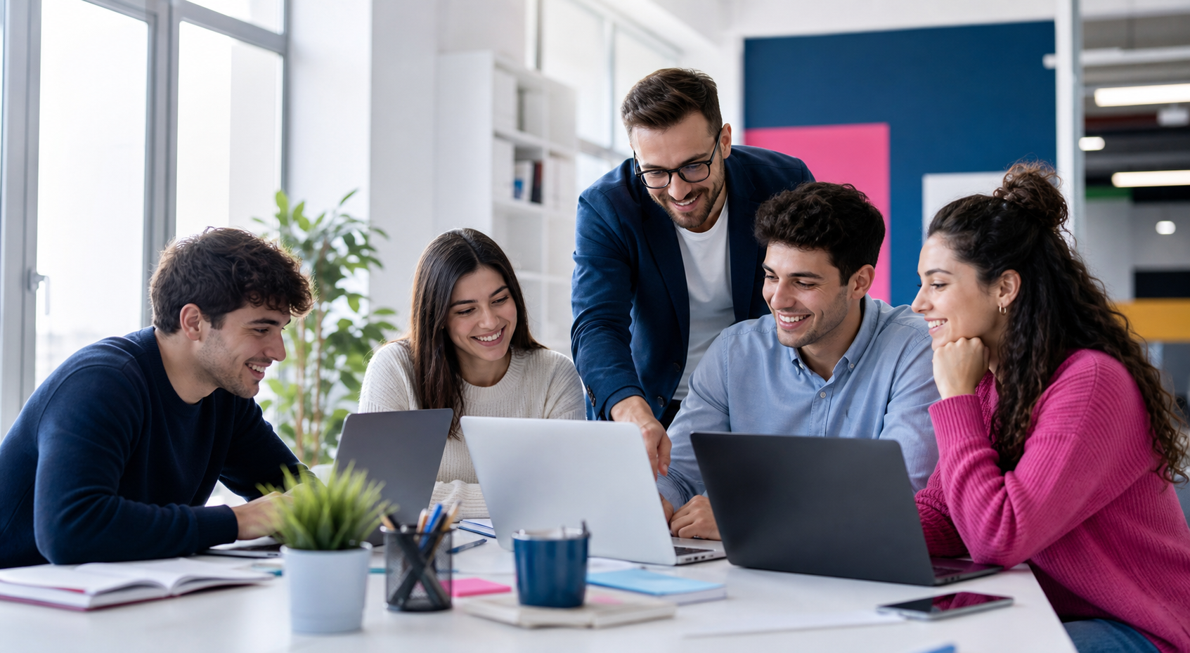 Giovani talenti e mentor collaborano con laptop in un ambiente formativo digitale